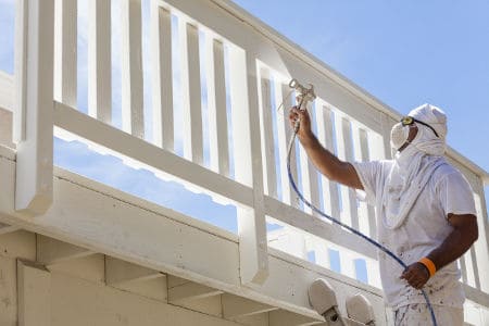 Spray Painting A Deck of A Home.